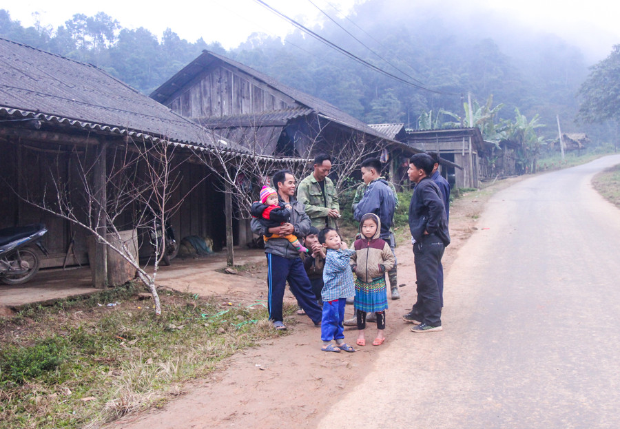 Bà con đổ ra đường trò chuyện, bàn luận về đào tết khiến không khí ở bản vùng cao này rộn ràng