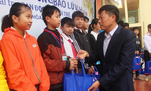 Thầy giáo Nguyễn Văn Giang - Hiệu trưởng Trường Tiểu học và THCS thị trấn Mường Lát trao quà Tết cho học sinh nhà trường.