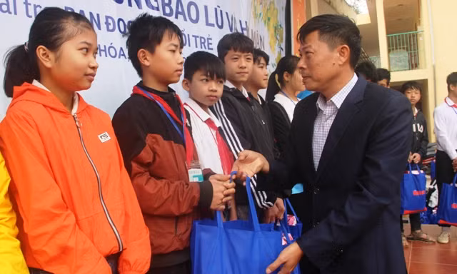 Thầy giáo Nguyễn Văn Giang - Hiệu trưởng Trường Tiểu học và THCS thị trấn Mường Lát trao quà Tết cho học sinh nhà trường.