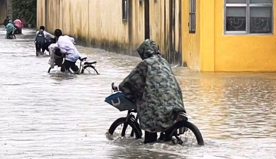 Nhiều học sinh liều mình lội nước đến lớp học. (Ảnh: Bạn đọc cung cấp)