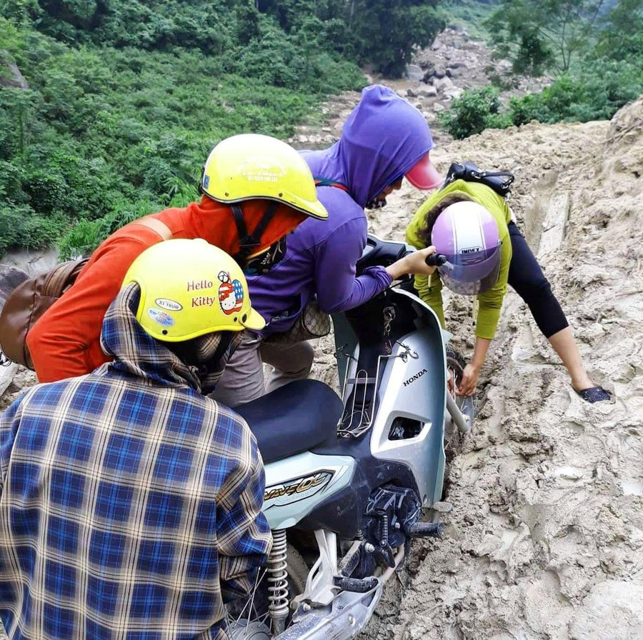 Cô Vui (áo tím) cùng đồng nghiệp hì hục đẩy xe đến trường sau trận mưa lũ lịch sử xảy ra tại Mường Lát năm 2018. Cô Vui (áo tím) cùng đồng nghiệp hì hục đẩy xe đến trường sau trận mưa lũ lịch sử xảy ra tại Mường Lát năm 2018.