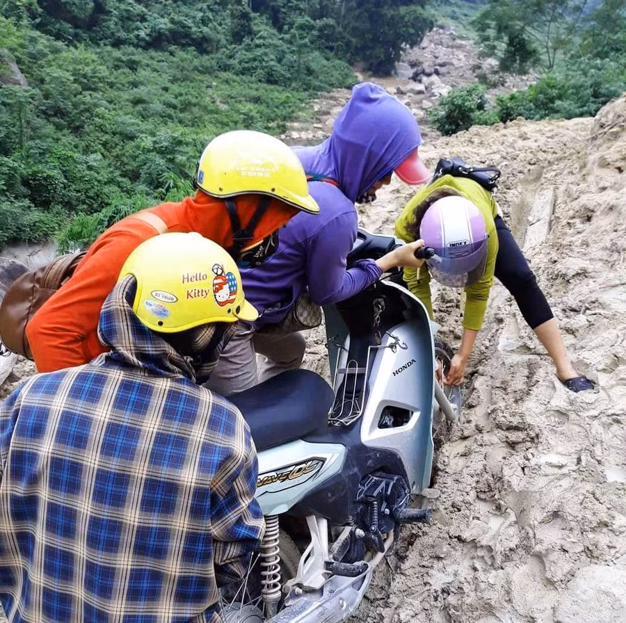 Cô Vui (áo tím) cùng đồng nghiệp hì hục đẩy xe đến trường sau trận mưa lũ lịch sử xảy ra tại Mường Lát năm 2018.
