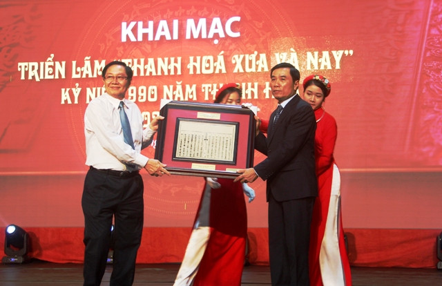 Ông Lê Vĩnh Tân (trái) - Bộ trưởng Bộ Nội vụ trao tặng Thanh Hóa phiên bản mộc bản triều Nguyễn về việc vua Lý Thái Tông cho đổi trại Ái Châu làm Thanh Hóa.