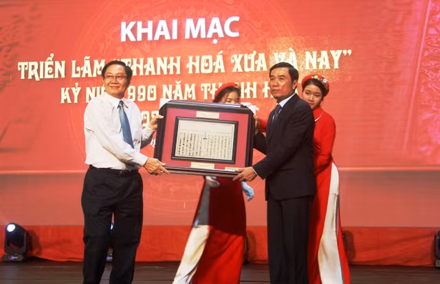 Ông Lê Vĩnh Tân (trái) - Bộ trưởng Bộ Nội vụ trao tặng Thanh Hóa phiên bản mộc bản triều Nguyễn về việc vua Lý Thái Tông cho đổi trại Ái Châu làm Thanh Hóa.