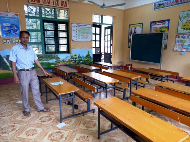Thầy giáo Lê Thiên Quang - Hiệu trưởng nhà trường chỉ nơi ngồi của Phước tại lớp học trước khi em bị sát hại.