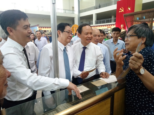 Nghe giới thiểu về tư liệu lịch sử tại triển lãm.