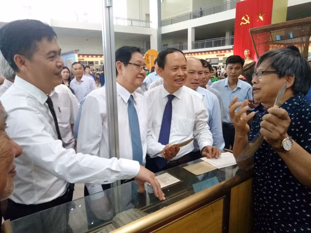 Nghe giới thiểu về tư liệu lịch sử tại triển lãm.