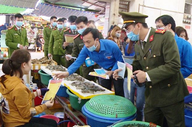 Cấp phát tờ rơi cho người dân hiểu về dịch bệnh do virus Corona. Ảnh: Công an cung cấp.