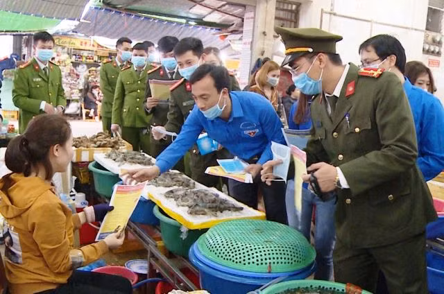 Cấp phát tờ rơi cho người dân hiểu về dịch bệnh do virus Corona. Ảnh: Công an cung cấp.