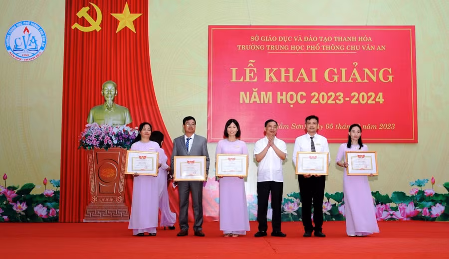 Ông Lê Văn Tú, Chủ tịch UBND TP Sầm Sơn (đứng giữa) dự Lễ khai giảng năm học 2023-2024 và trao thưởng các thầy, cô giáo Trường THPT Chu Văn An. Ảnh: NTCC.