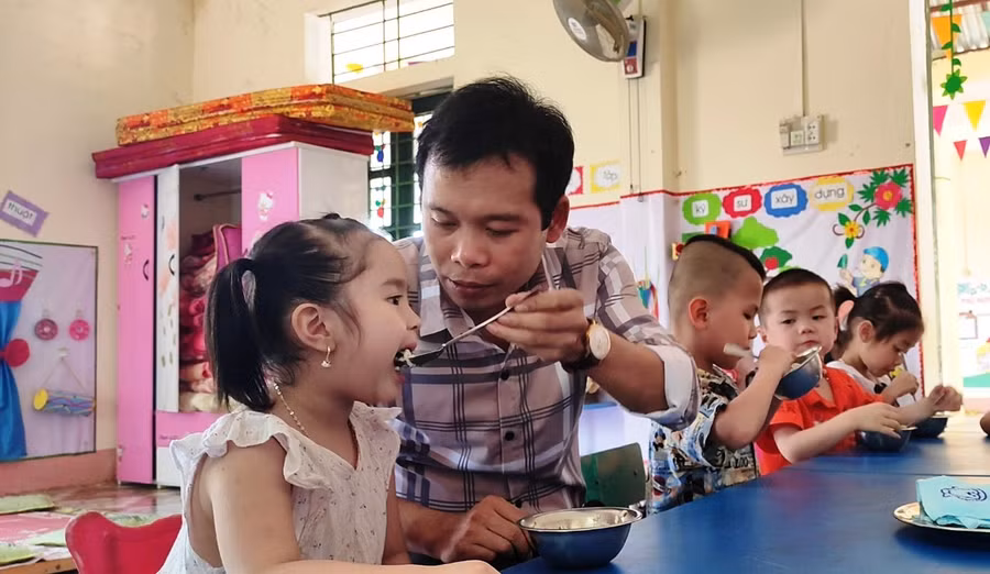 Thầy Trịnh Hồng Quân - Hiệu trưởng Trường Mầm non Thành Sơn (Bá Thước, Thanh Hóa) đang chăm sóc trẻ. Ảnh: Thế Lượng