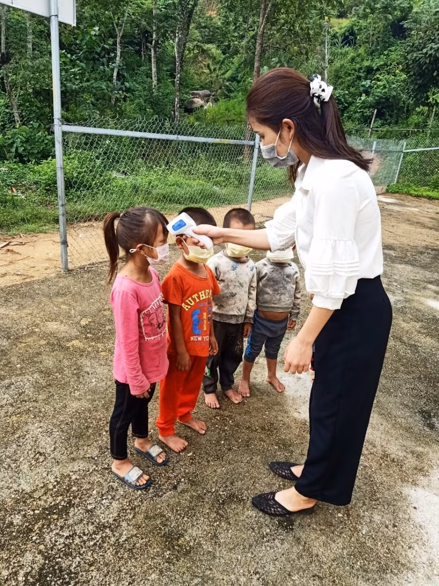 Đo thân nhiệt cho các con.