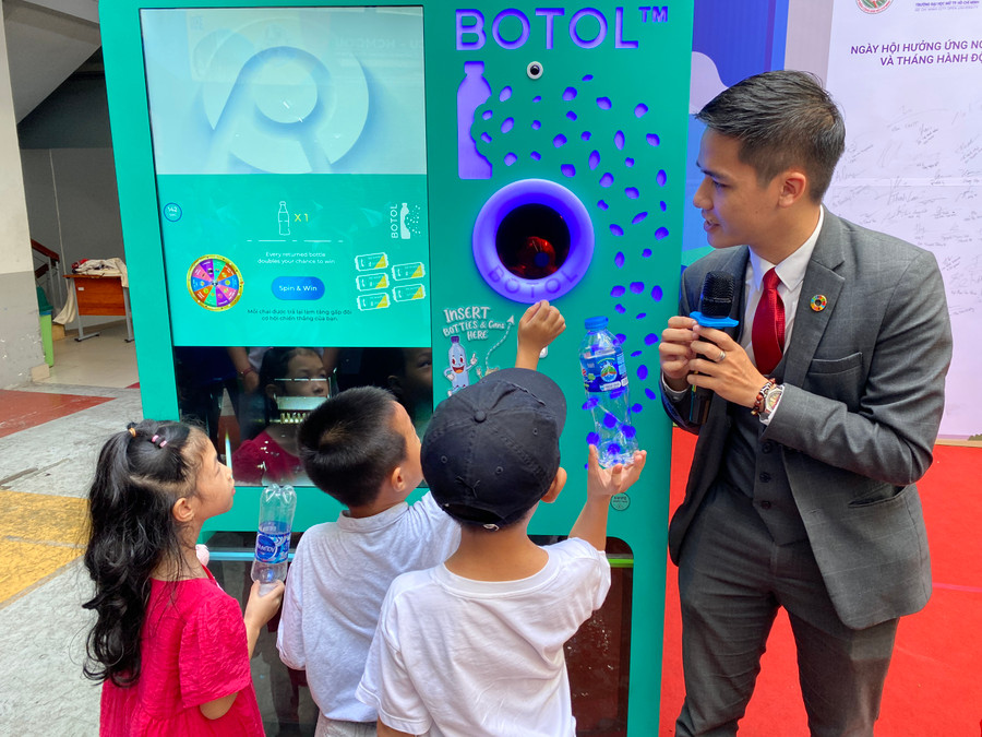 Các em nhỏ hào hứng bỏ rác thải vào máy xử lý. (Ảnh: L.N) Các em nhỏ hào hứng bỏ rác thải vào máy xử lý. (Ảnh: L.N)