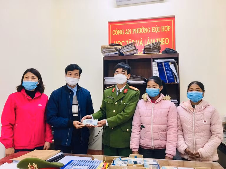 Công an phường Hội Hợp và em Mai trao lại số tiền cho người bị mất. Ảnh: Công an tỉnh Vĩnh Phúc