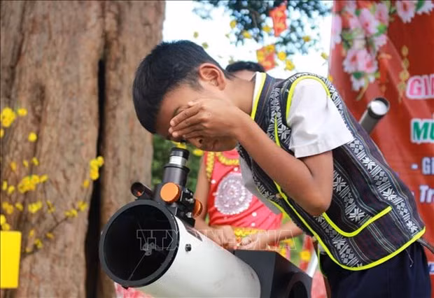 Học sinh tiểu học ở huyện Khánh Vĩnh ngắm bầu trời qua thiết bị thiên văn trong chương trình khoa học trải nghiệm. Ảnh: TTXVN