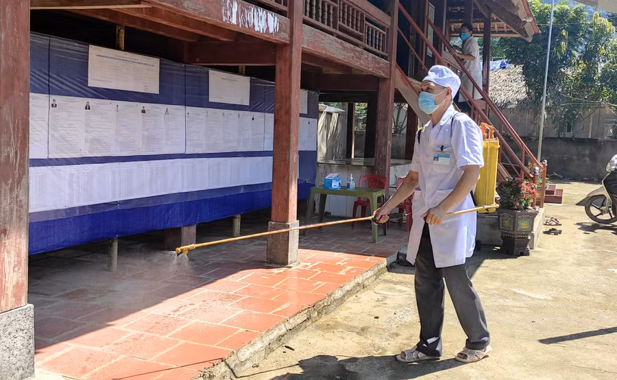 Lực lượng Y tế phun hóa chất khử khuẩn tại điểm bầu cử (nhà văn hóa bản Hậu, xã Tam Lư, Quan Sơn).