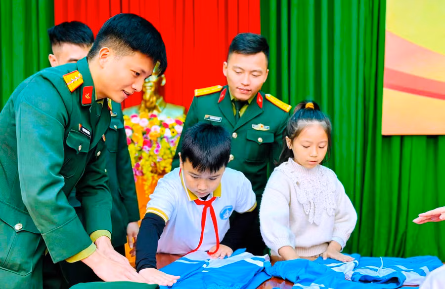 Học sinh được tham gia trải nghiệm gấp quần áo, chăn màn... do các chú Bộ đội hướng dẫn. Ảnh: NTCC