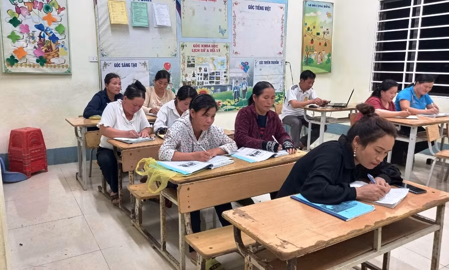 Những phụ nữ của lớp học chăm chỉ tập viết. Ảnh: NG.Đ.