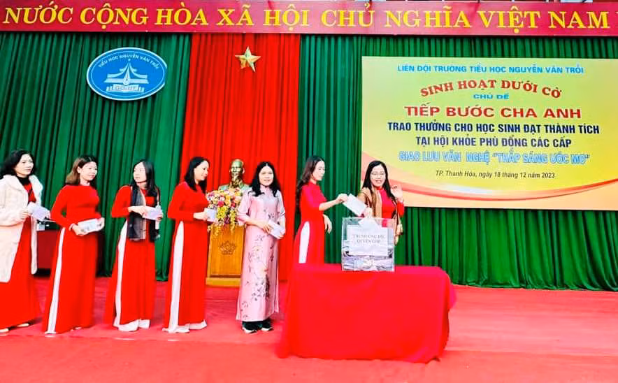 Cán bộ, giáo viên, nhân viên nhà trường quyên góp hỗ trợ trẻ em tàn tật Việt Nam, học sinh nghèo dịp Tết Nguyên đán. Ảnh: NTCC