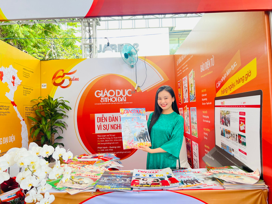 Phóng viên Báo Giáo dục và Thời đại giới thiệu các ấn phẩm của báo. (Ảnh: Anh Tú)