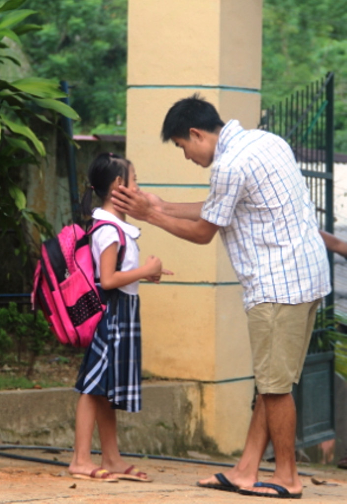 Âu yếm, dặn dò con gái trước khi vào lớp.