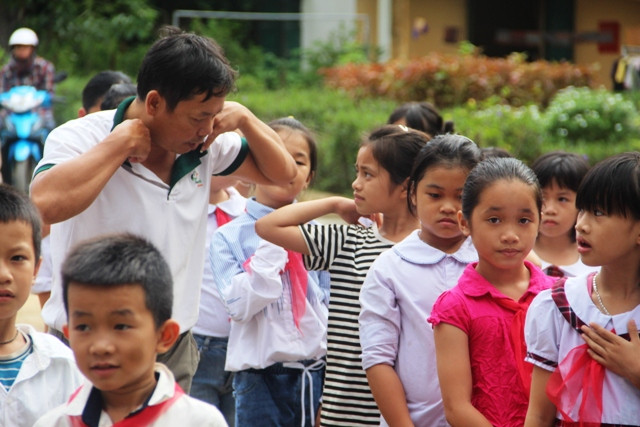 Tận tình hướng dẫn học sinh thắt khăn quàng đỏ.