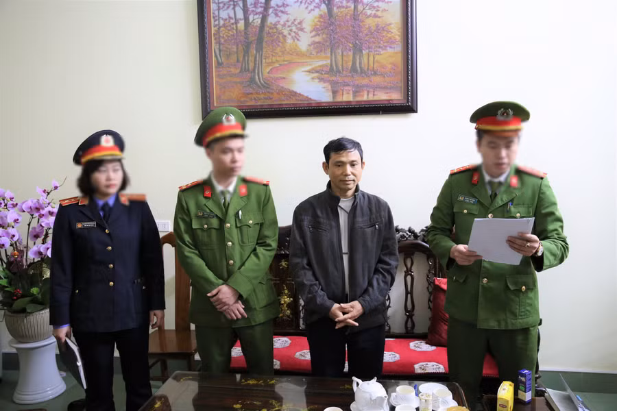 Cơ quan chức năng đọc lệnh khám xét, tạm giữ cán bộ Trung tâm đăng kiểm xe cơ giới tỉnh Nghệ An. Ảnh: CANA.