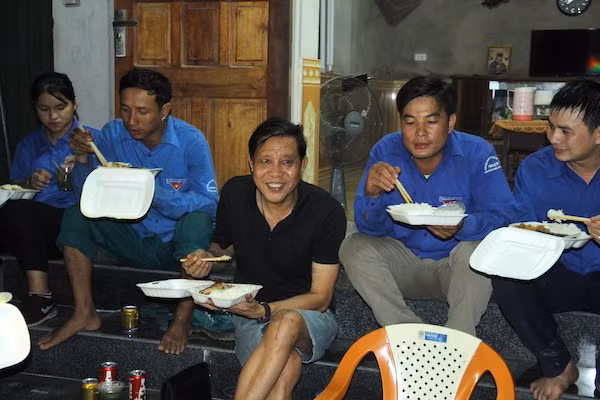 Ông Lê Văn Hồng (áo đen) trực tiếp đem cơm sang Nghi Xuân, Hà Tĩnh và cùng ngồi ăn với đoàn thanh niên