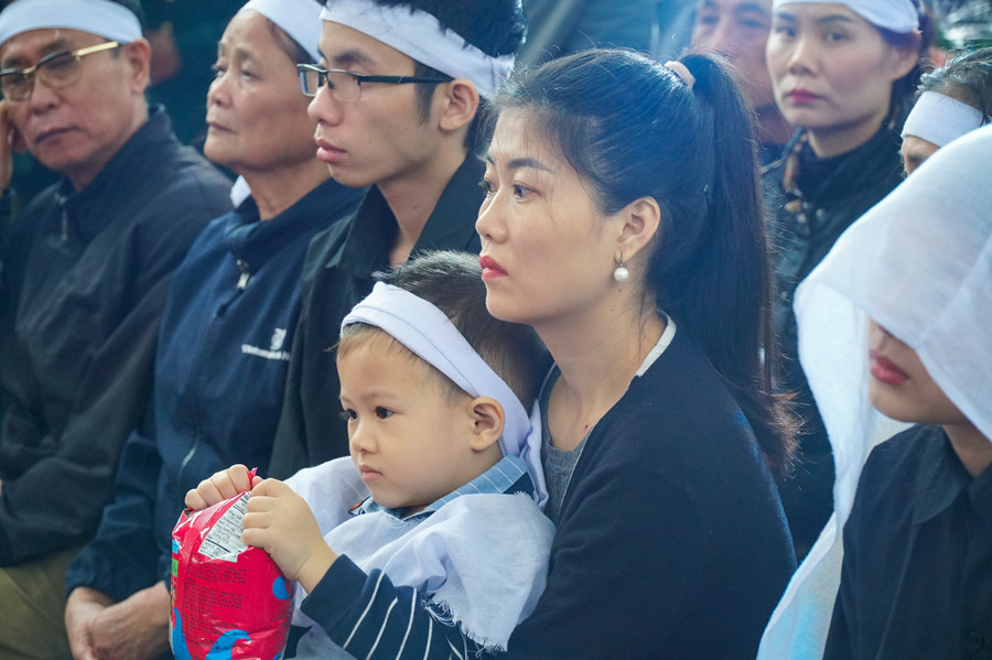 Con của liệt sỹ Đinh Văn Trung vẫn quá nhỏ đểu hiểu nỗi đau mất cha. Cháu bé ngồi lọt trong tay người thân, ngơ ngác trong lễ tang của cha.