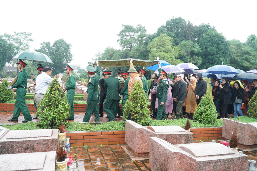 Trời mưa tầm tã, cán bộ chiến sĩ phải căng tấm nilong để che mưa cho hài cốt liệt sỹ
