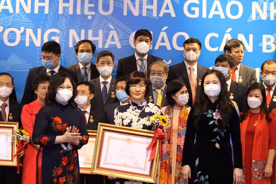 Thứ trưởng Ngô Thị Minh (hàng đầu bên trái) và bà Nguyễn Thị Bích Hợp (hàng đầu bên phải) trao danh hiệu Nhà giáo Ưu tú