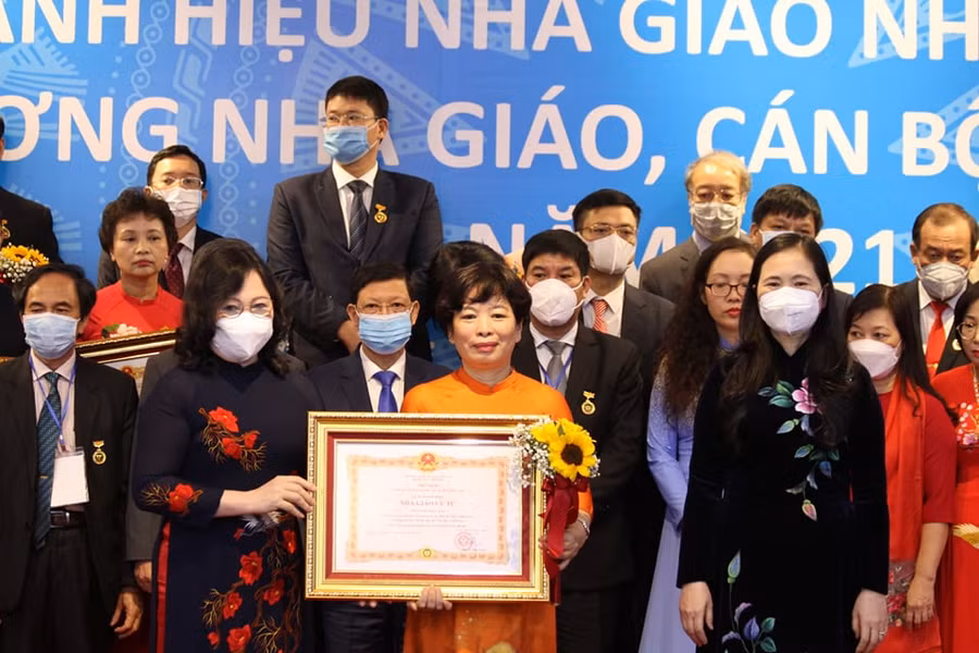 Thứ trưởng Ngô Thị Minh (hàng đầu bên trái) và bà Nguyễn Thị Bích Hợp (hàng đầu bên phải) trao danh hiệu Nhà giáo Ưu tú cho cán bộ quản lý