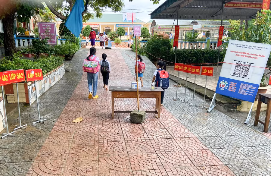 Nhà trường phân luồng lối vào cho học sinh, để sẵn nước rửa tay sát khuẩn và khẩu trang để các em sử dụng