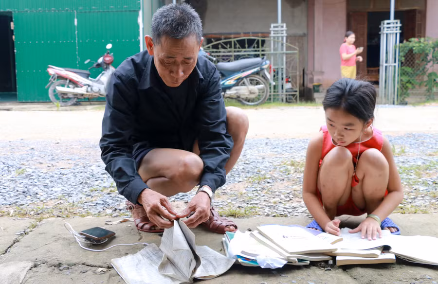 Em Nguyễn Thị An Phượng và ông (huyện Thanh Chương, Nghệ An) đang phơi lại sách vở bị ướt sau lũ. Hiện, nhiều trường học tại các huyện Thanh Chương, Nam Đàn, Đô Lương, Yên Thành chưa thể trở lại dạy học vào tuần tới. Các huyện còn lại, mức độ thiệt hại ít hơn, học sinh sẽ bắt đầu trở lại trường từ thứ 2, ngày 2/11.