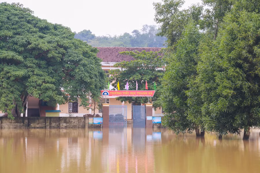 Trước đó, tối 29/10, nước lũ bất ngờ dâng nhanh khiến trường Tiểu học Thanh Hà (huyện Thanh Chương) chìm trong biển nước. Đến nay, nhà trường vẫn chưa thể dọn dẹp vệ sinh con đường phía trước trường vẫn ngập sâu hơn 1m, nguy hiểm trong việc đi lại.