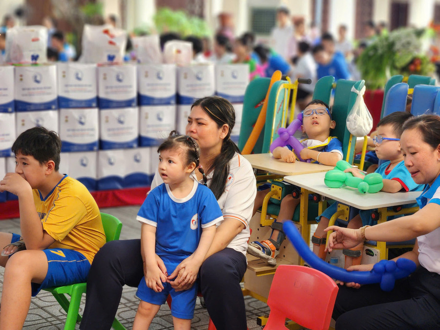 Các em nhỏ cùng các cô chăm chú xem chương trình Trung thu tại trung tâm. Ảnh: H.P