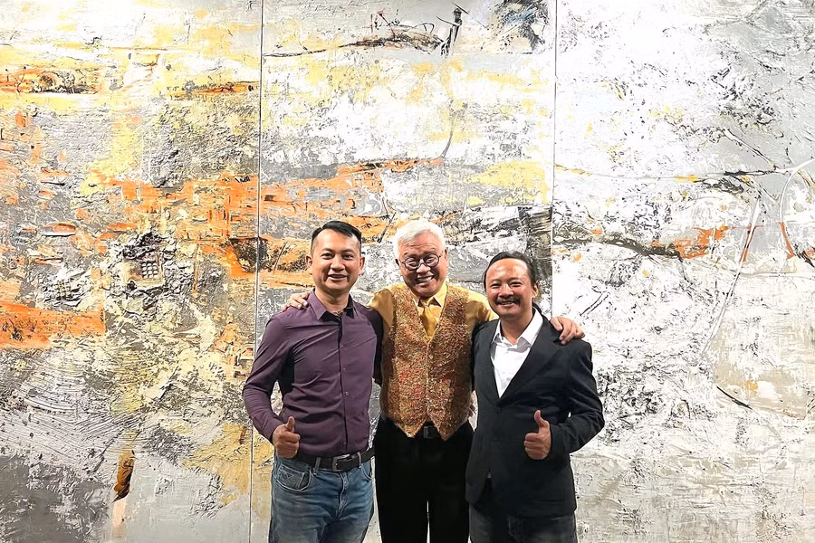 Họa sĩ Ngô Thanh Hùng (bìa phải) chụp ảnh cùng khách tham quan triển lãm.