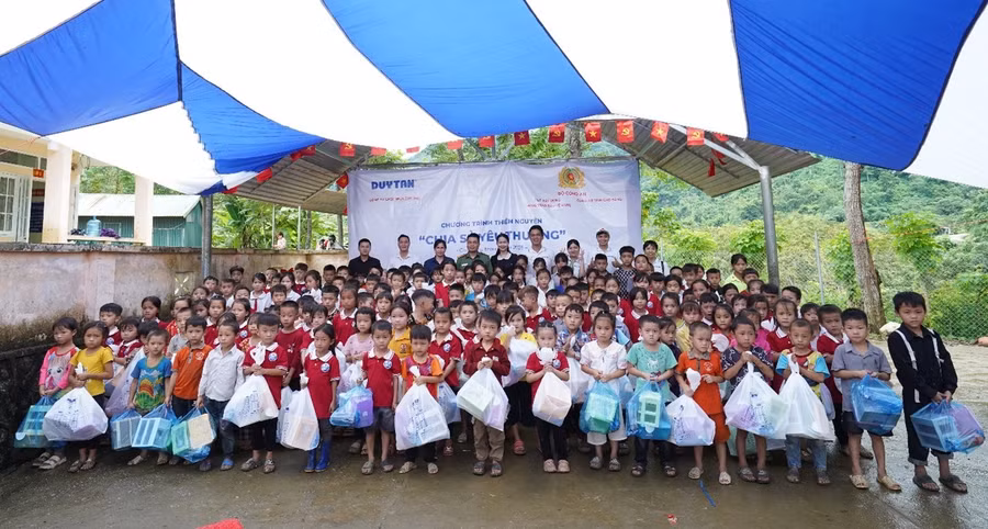 Cục Xây dựng phong trào bảo vệ ANTQ, công an tỉnh Cao Bằng và đại diện Nhựa Duy Tân, tặng quà cho điểm Trường Tiểu học Nà Đon (xã Quảng Lâm). Ảnh: BTC
