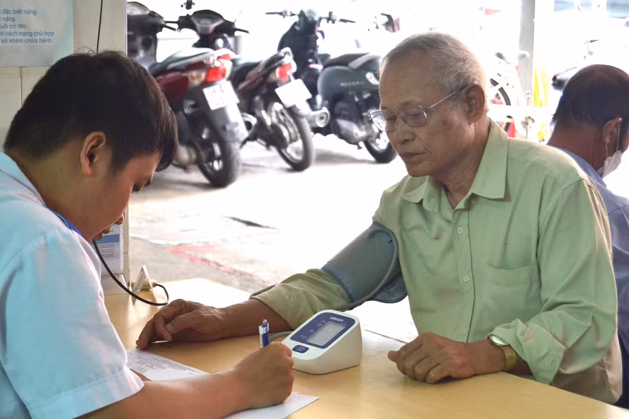 Cán bộ y tế kiểm tra huyết áp và tư vấn phác đồ điều trị phù hợp cho người có công với cách mạng. Ảnh: H.P