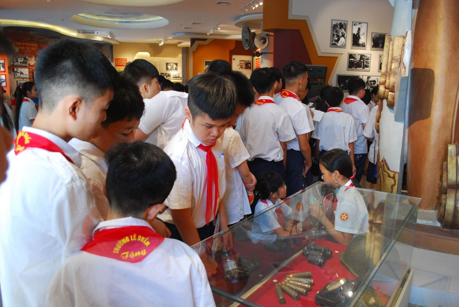 Các em học sinh quan sát hiện vật lịch sử được trưng bày tại bảo tàng. Ảnh: ITN r.jpg