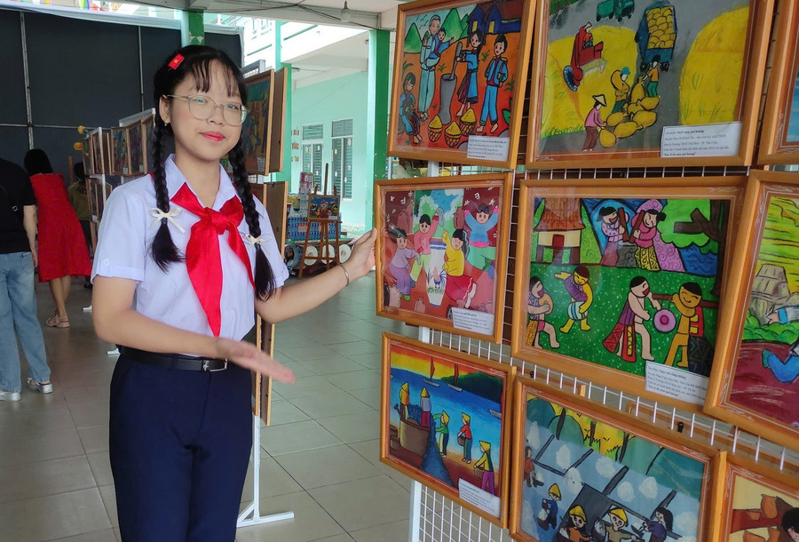 Em Bùi Thị Thùy Trâm, học sinh lớp 7A1, Trường THCS Nguyễn Viết Xuân giới thiệu các bức tranh của bạn. Ảnh: Nhà thiếu nhi Bình Dương 504916615-1291535882354665-1748699713677476781-n.jpg