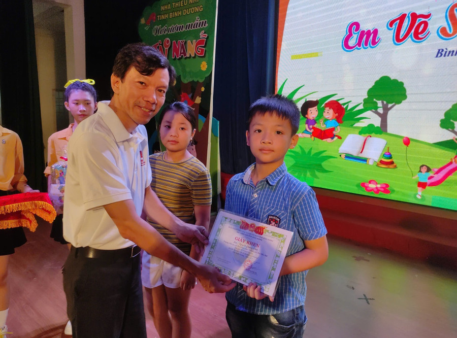 Anh Nguyễn Phan Thái Anh trao giải cho thí sinh nhí đạt giải B trong cuộc thi. Ảnh: Nhà thiếu nhi Bình Dương 504908563-1291536175687969-5744969439253813494-n.jpg