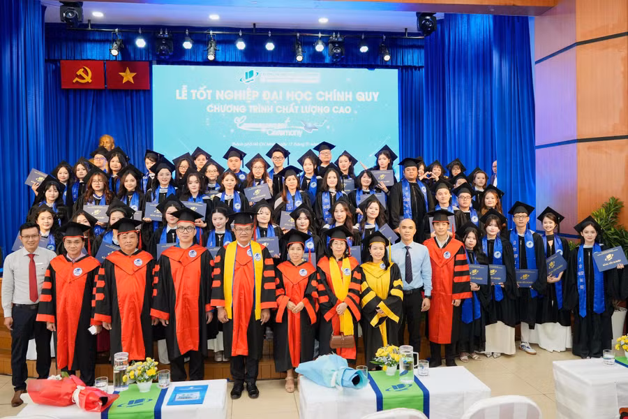 Các tân cử nhân chụp ảnh lưu niệm cùng thầy cô và Ban Giám hiệu nhà trường.