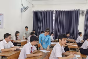 Cán bộ làm công tác thi hướng dẫn thí sinh rà soát, đối chiếu thông tin trên thẻ dự thi. 