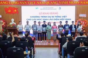 Đại diện Ban giám hiệu Trường Đại học Ngoại ngữ, Đại học Đà Nẵng tặng quà lưu niệm cho lưu học sinh Lào trong lễ khai giảng. 