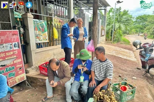 Sinh viên tình nguyện Trường Đại học Bách khoa - Đại học Đà Nẵng hỗ trợ người dân sử dụng dịch vụ công bằng thao tác trên điện thoại.