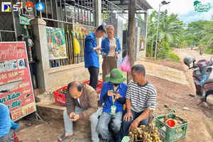 Sinh viên tình nguyện Trường Đại học Bách khoa - Đại học Đà Nẵng hỗ trợ người dân sử dụng dịch vụ công bằng thao tác trên điện thoại. 