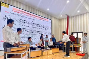 Giáo viên âm nhạc thực hành với các loại nhạc cụ để tổ chức hoạt động hòa tấu đơn giản tại lớp tập huấn. 