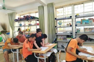 Cô giáo Nguyễn Thị Thu Huyền với học sinh lớp Giáo dục đặc biệt 3. Ảnh: Vũ Minh. 