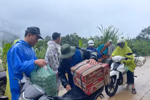 Lực lượng tình nguyện vận chuyển nhu yếu phẩm tiếp tế cho người dân đang tránh trú tại điểm trường Lăng Lương. Ảnh: Trà Thu. 
